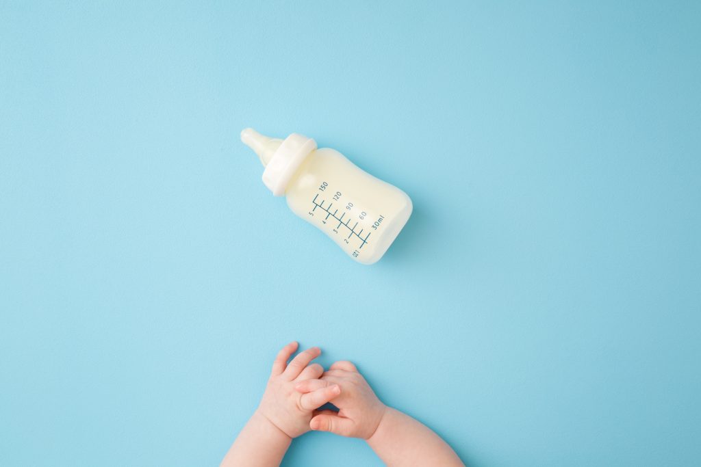 Milk bottle near kid hands